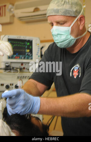 Le Major de l'ARMÉE AMÉRICAINE Michael Cline, 759e de l'avant de l'équipe chirurgicale, de Fort Bragg, N.C., CRNA anesthésiste affecté à Camp Wright, Asadabad, intubates un patient avant une chirurgie orthopédique à la FST du camp le 15 octobre. Cette intervention était pour un membre de la police nationale afghane qui a reçu une balle à la jambe en l'exercice de ses fonctions dans la zone locale. Après avoir reçu une intervention chirurgicale immédiate pour réparer sa blessure, il a été transféré à un autre endroit pour recevoir des soins spécialisés et à long terme. Le TSF a surtout pour but d'offrir un traitement chirurgical local immédiat pour blessures mettant la vie en danger de Banque D'Images