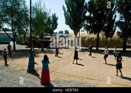 Les membres du service et les enfants jouent un match amical de volley-ball au cours d'une visite au centre de transit de Manas, au Kirghizistan, le 14 juillet 2012. Le centre de transit de la division de la coopération en matière de sécurité dans le théâtre a passé la journée avec les enfants de l'orphelinat des enfants d'Amis de renforcer l'amitié et d'interagir avec les enfants. Banque D'Images