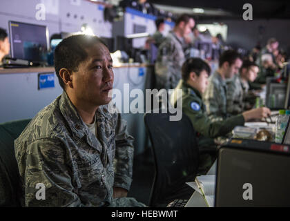 U.S. Air Force Le Major David Tomiyama travaille sur les questions des médias aux côtés de République de Corée officiers de la Force aérienne le 10 mars 2015, dans la République de Corée et de l'espace Air Operation Center lors de l'exercice Key Resolve à Osan Air Base, République de Corée. Tomiyama est un officier des affaires publiques de la 713ème escadron de combat, Joint Base Harbor-Hickam Pearl, Washington. (U.S. Photo de l'Armée de l'air par le sergent. Shawn/nickel libéré) Banque D'Images