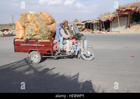 Un homme et une femme afghane ride à Arghandab, en Afghanistan, pendant que les soldats américains avec la Compagnie Charlie, 1er Bataillon, 17e Régiment d'infanterie, 5e Brigade, 2e Division d'infanterie, patrouillent dans les rues le 7 novembre 2009. La Compagnie Charlie a pour mission de soutenir l'ensemble de la Force internationale d'assistance à la sécurité a pour mission d'aider le gouvernement afghan à établir et maintenir un environnement sûr et sécurisé, facilitant ainsi la stabilité et la reconstruction du pays. (U.S. Air Force photo de Tech. Le Sgt. Francisco C. Govea II/libérés) Banque D'Images