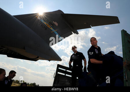 Le s.. Jacob Richmond, un spécialiste des relations avec la communauté des affaires publiques, les déchargements valises près du C-17 Globemaster, en préparation au départ Graf Ignatievo Air Base, la Bulgarie pour RAF Waddington, au Royaume-Uni le 28 juin, 2011. Les Thunderbirds se produira dans 9 pays durant leur tournée européenne de six semaines, la promotion de la bonne volonté internationale et représentant de l'Amérique d'aviateurs du monde entier. (U.S. Air Force photo/Le s.. Larry E. Reid Jr., sorti) Banque D'Images