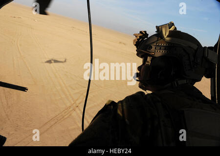 Le sergent de l'US Air Force. Demian Abel, un cavalier de sauveteurs-parachutistes de la 66e Escadron de sauvetage expéditionnaire, numérise l'horizon pour des menaces potentielles provenant de son HH-60G Pave Hawk au cours de la mission d'évacuation médicale, le 10 janvier, plus de la province de Kandahar, Afghanistan. (U.S. Air Force photo/Le s.. Manuel J. Martinez/libérés) Banque D'Images