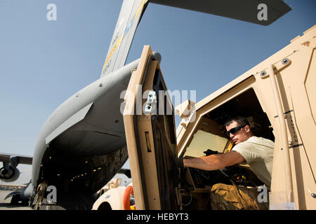 Cody Bard, Senior Airman 455 e escadron expéditionnaire aérienne Port Aérien porter, conduit un véhicule protégé Mine-Resistant embuscade sur un C-17A Globemaster III, à l'aérodrome de Bagram, en Afghanistan, le 2 octobre 2013. Bagram est devenue une importante plaque tournante pour les opérations en arrière hors de l'Afghanistan. La 455 e section de manutention spéciale PAE 4.2 millions de livres de poussée de l'équipement arrière pendant le mois de septembre. Bard, un natif d'Austin, au Texas, est déployée à partir de Joint Base Lewis-McChord, dans l'État (Photo USAF/Master Sgt. Ben Bloker) Banque D'Images