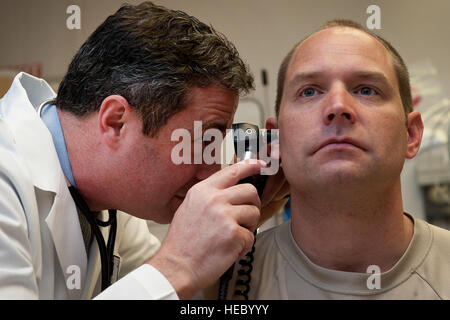 Sean Harap, Tripler Army Medical Center, le médecin effectue un examen physique pour l'US Air Force Le Capitaine Joshua Gscheidmeier, 128e Escadre de ravitaillement en vol, à Tripler Army Medical Center 8 mai 2014, à Honolulu. La ligne d'avis de l'infirmière est mis à offrir une alternative aux bénéficiaires TRICARE obtenir des soins médicaux à compter du 30 mai. L'avis a été conçue pour offrir aux patients un moyen de recevoir de l'information, l'évaluation médicale, l'orientation et de soins avant de choisir si oui ou non la visite d'une salle d'urgence est nécessaire. (U.S. Photo de l'Armée de l'air par le sergent. Christopher Hubenthal) Banque D'Images