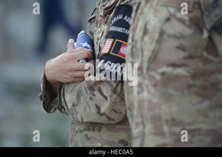 Un membre de la garde d'honneur de l'US Air Force tient le drapeau américain lors d'une cérémonie de retraite au Camp Cunningham, sur l'aérodrome de Bagram, en Afghanistan, le 11 septembre 2014, marquant l'anniversaire des attentats terroristes du 11 septembre 2001 avec plus de 200 aviateurs présents. Banque D'Images