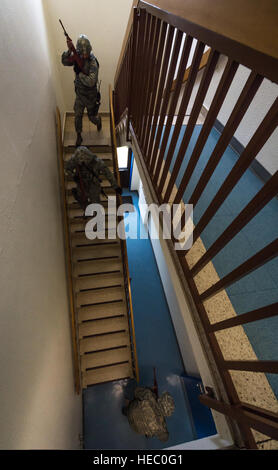 Les aviateurs américains affectés à la 86e Escadron des Forces de sécurité effacer un escalier au cours d'un scénario de formation et de tir, 9 avril 2014, à la base aérienne de Ramstein, en Allemagne. L'exercice a été conçu pour évaluer les compétences lors de la réponse à un environnement inconnu qui inclus un tireur actif tir à blanc tours avec simulation de victimes civiles. (U.S. Air Force photo par un membre de la 1re classe Jordanie Castelan/libérés) Banque D'Images