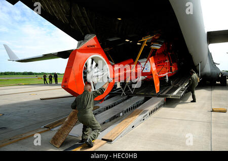 Les aviateurs américains charger un MH-65C hélicoptère Dauphin, affecté à la Garde côtière des États-Unis, de l'escadron tactique d'interdiction de l'hélicoptère sur un C-17 Globemaster III sur la base aérienne de Charleston, S.C., le 3 juillet 2010. Aviateurs mènent contre la drogue et la formation des équipages de missions au cours de cinq jours d'affectations temporaires à El Salvador, Panama, Porto Rico et les États-Unis. (U.S. Air Force photo de Tech. Le Sgt. Dennis J. Henry Jr./libérés) Banque D'Images