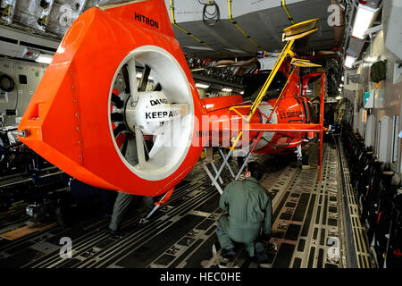 Les aviateurs américains charger un MH-65C hélicoptère Dauphin, affecté à la Garde côtière des États-Unis, de l'escadron tactique d'interdiction de l'hélicoptère sur un C-17 Globemaster III sur la base aérienne de Charleston, S.C., le 3 juillet 2010. Aviateurs mènent contre la drogue et la formation des équipages de missions au cours de cinq jours d'affectations temporaires à El Salvador, Panama, Porto Rico et les États-Unis. (U.S. Air Force photo de Tech. Le Sgt. Dennis J. Henry Jr./libérés) Banque D'Images