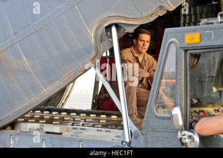 Le s.. Johnny Bond, arrimeur avec le 737th Escadron de transport aérien expéditionnaire, guide le conducteur d'un chariot élévateur à l'arrière d'un U.S. Air Force C-130J dans un endroit inconnu en Asie du Sud-Ouest. Bond est déployé à partir de la 146e Airlift Wing, California Air National Guard et est originaire de San Fernando, Californie (États-Unis Air Force photo de 1er lieutenant Holli Nelson) Banque D'Images