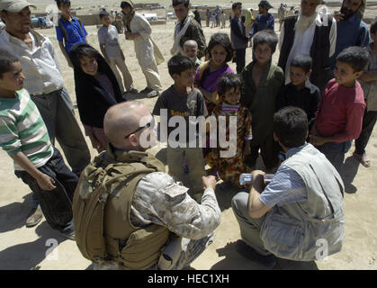 Le major du Corps des Marines américain Brian Rush(en bas à gauche), un membre de la transition conjointe de la sécurité (CSTC-A) des entretiens avec un groupe d'enfants après l'acheminement d'une des personnes déplacées internes (IDP) camp en dehors de Kaboul, Afghanistan, le vendredi 27 juillet 2007, d'offrir des dons envoyés depuis les Etats-Unis. Le camp abrite environ 585 familles. La CSTC-A, composé de membres et conjoints de militaires internationales, fonctionnaires et entrepreneurs basés à Camp Eggers, recueillir toutes les deux semaines en vertu de la communauté de bénévoles Relations (Magnétoscope) programme à réaliser les vêtements, jouets, Banque D'Images