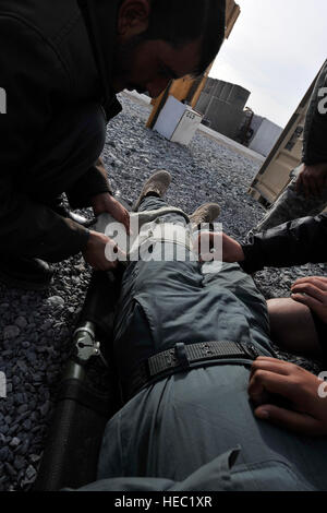 Les policiers nationaux afghans apprennent les techniques de bandage de soldats américains affectés au 402ème Bataillon de soutien de la Brigade au cours de l'Équipe spéciale de l'académie de formation de la Légion au poste de combat Rath, province de Kandahar, Afghanistan, le 24 décembre 2009. (U.S. Photo de l'Armée de l'air par le sergent. Mitchell de Dayton/libérés) Banque D'Images