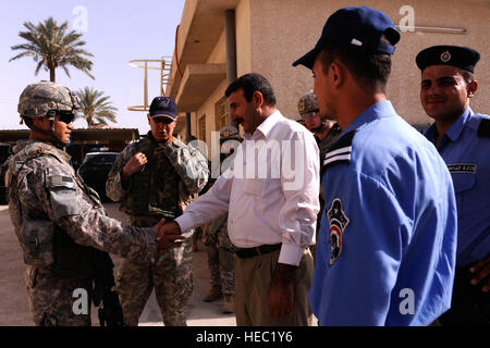 1er de l'armée américaine. Le Lieutenant Erik Kifune, du 1er Bataillon, 5e Régiment d'infanterie, 1ère Stryker Brigade Combat Team, 25e Division d'infanterie, et son interprète rencontrez avec l'Iraq, les responsables de la Police de la ville de Buhrizf, l'Iraq, le 27 avril. Banque D'Images