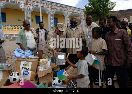 Le Capitaine de vaisseau américain Tom Broderick, le dévouement de groupe de forces interarmées officier - Corne de l'Afrique, fait don de fournitures scolaires à la suite d'une cérémonie de dédicace à Assamo, à Djibouti. La cérémonie a célébré l'achèvement des ajouts à l'école primaire, qui inclu trois prix dortoir, repas extérieur, cuisine équipée, clôture, panneaux solaires, latrines et trois puits. Banque D'Images