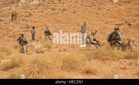 Soldats affectés au 3e Peloton, Fox Company, 2e Escadron, 2e Stryker Cavalry Regiment et la Police nationale afghane prendre une petite pause lors d'une patrouille à pied près de l'avant poste Mizan, Mizan District, province de Zabul, août 26. Des membres du 3e Peloton, l'Équipe de reconstruction provinciale de Zabul et forces de sécurité nationale afghanes patrouillait la région de rencontrer les aînés et d'assurer la sécurité dans la région. Banque D'Images