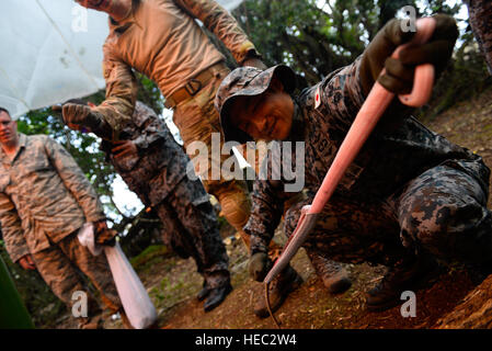 Japan Air Self-Defense Force Pararescueman Tech. Le Sgt. Shinchiro Sasaki, droite, skins un serpent brun arboricole au cours d'une survie dans la jungle d'échange d'experts en la matière, le 16 février 2016, à la base aérienne d'Andersen, Guam. Faire face au Nord 16 exercice comprend 22 unités de vol total et près de 3 000 membres de six pays et poursuit la croissance de strong, interopérables et bénéfique des relations au sein de l'Indo-Asia-région du Pacifique par l'intégration de l'aéroporté et des actifs de commandement et de contrôle. (U.S. Photo de l'Armée de l'air par le sergent. Alexander W. Riedel/libérés) Banque D'Images