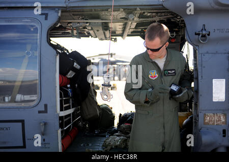 Les cadres supérieurs de l'US Air Force Airman Jacob Ellwood, un HH-60G Pave Hawk ingénieur de vol avec le 129e Escadron de sauvetage, California Air National Guard, effectue des vérifications de contrôle en amont d'une base commune à Harbor-Hickam Pearl, Washington, le 24 juillet 2012, avant qu'un de recherche et sauvetage de combat pour la mission de formation de l'exercice RIMPAC 2012. L'EXERCICE RIMPAC est un américaines du Pacifique a organisé l'exercice maritime multinational biennal destiné à encourager et soutenir la coopération internationale sur la sécurité du monde ?s des océans. (U.S. Photo de l'Armée de l'air par le sergent. Jason Robertson/libérés) Banque D'Images