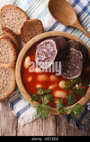 Délicieuse soupe avec du boudin noir Fabada Asturiana close up dans un bol en bois vertical Vue de dessus. Banque D'Images