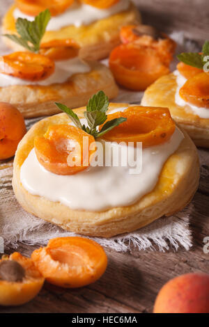 Feuilletés aux abricots avec de la crème sur la table. vertical Banque D'Images