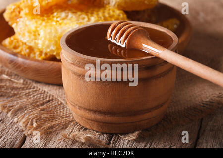 Miel frais dans un bol en bois et un gros plan sur la table horizontale. Banque D'Images