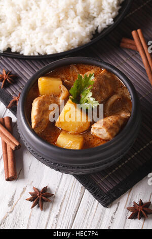 Kaeng thaï curry massaman avec du poulet dans un bol et le riz sur la table verticale. Banque D'Images