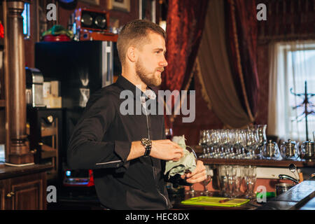 Barman est d'essuyer un verre Banque D'Images