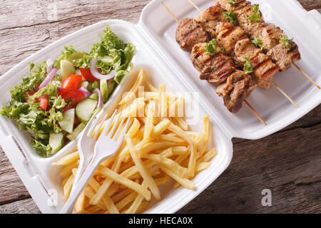 Boîte à lunch : Brochettes, frites et salade fraîche dans le bac sur la table. L'horizontale Banque D'Images