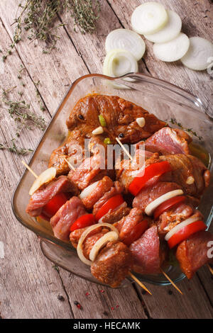 Kebab avec des légumes crus dans la marinade sur les brochettes, close-up à la verticale Banque D'Images