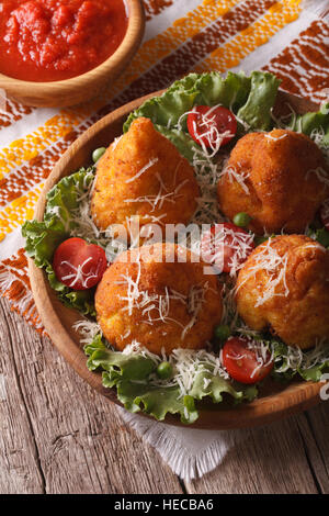 Arancini de boules de riz farcies de viande et de la sauce tomate libre sur une table. La verticale Banque D'Images