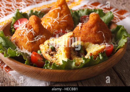 Arancini de boules de riz avec de la viande et les pois gros plan sur une assiette. L'horizontale Banque D'Images