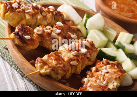 Satay de poulet, sauce aux arachides et de la salade sur une assiette horizontale macro. Banque D'Images