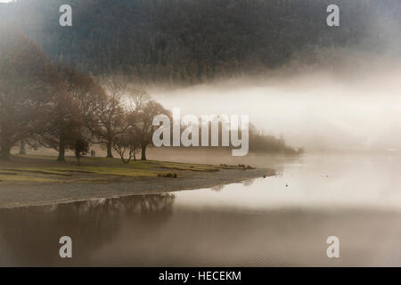 Mist envahissent le paysage sur la rive du lac de Derwentwater Keswick à l'aube dans le Lake District, Cumbria UK en hiver Banque D'Images