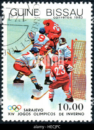 Un timbre imprimé en Guinée-Bissau, dédié aux jeux olympiques d'hiver de Sarajevo - 84, présente le hockey Banque D'Images