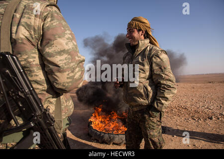 La Syrie. Dec 19, 2016. Aller à RAQQA - 19/12/2016 - Syrie/Rojava - SYRIE/ROJAVA QALLAT village Jabber/la nuit d'avant, ce village a été libéré de l'ISIS. Un soldat GPJ prendre le devant un grand feu. - Chris Huby/Le Pictorium © Le Pictorium/Alamy Live News Banque D'Images