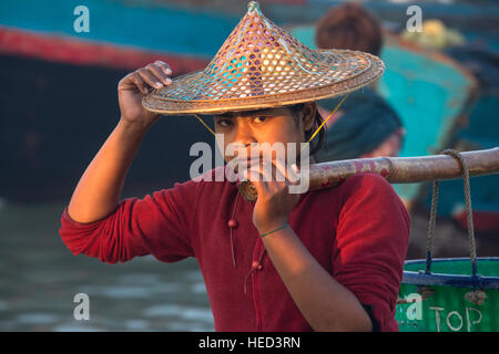 Femme birmane réunissant les nuits à terre des prises à l'aube, près du village de pêcheurs sur la plage de Ngapali en Birmanie (Myanmar). Banque D'Images