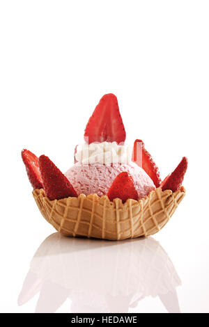 Glace à la fraise, crème fouettée et les fraises dans un bol de wafer Banque D'Images