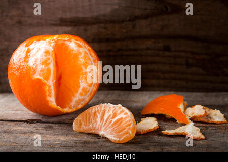 La mandarine fraîches pelées et une coupe sur une table en bois Banque D'Images