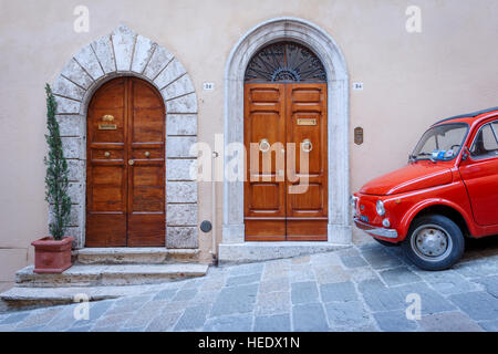 Une Fiat 500 rouge garée à côté de deux portes renaissance à Montepulciano, Toscane, Italie. Banque D'Images