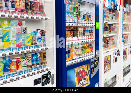 Le Japon. Vue en gros le long de la rangée de quatre des distributeurs de boissons, chacun avec l'affichage de différents types de bouteilles et boîtes à boutons de commande. Banque D'Images