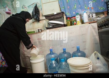 Les familles luttent pour rationner l'eau potable de la ville de Zarqa, en Jordanie. Banque D'Images