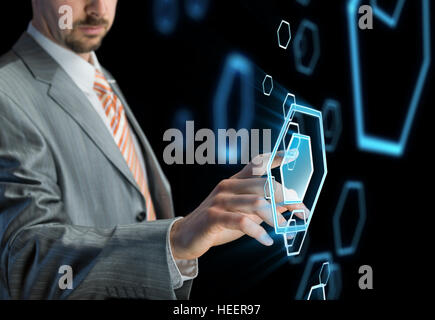 Businessman touching bouton sur l'écran virtuel futuriste, fond noir Banque D'Images