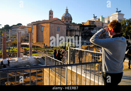 Le Forum Romain, le centre historique de Rome, Italie. Un touriste à regarder le coucher du soleil sur les ruines de l'Empire romain. Banque D'Images