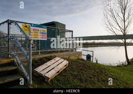 Vannes d'équipement électrique et de multiples signes vu par une rivière, à proximité d'un canal de navigation de plaisance. Banque D'Images