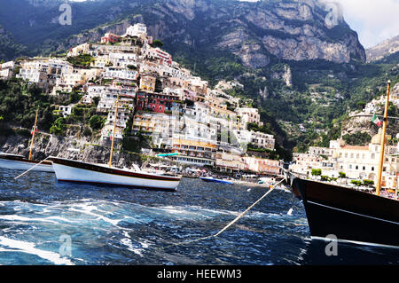 Les petits navires naviguant le long de la ligne de côte à Praiano, côte amalfitaine - Italie Banque D'Images