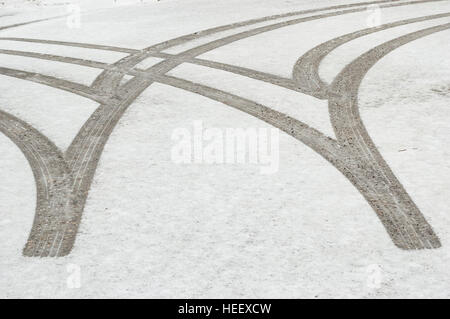 Les traces de pneus / les marques dans la neige fraîche sur une route pavée. Banque D'Images