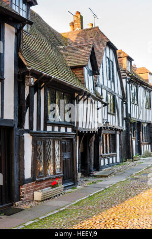 English Historique ville de Rye. Route pavée, avec cadre en bois noir Tudor médiéval et maisons de plâtre vers 16ème siècle. Tôt le matin, le soleil. Banque D'Images