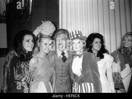 Imitateur féminin, Danny La Rue, versé son faites glisser l'image pour répondre à l'investiture du concours Miss Monde 1970 à Londres. M. La Rue (au centre) pose avec l'investiture de Miss Monde (l-r) AFET Tugbay (Miss Turquie), Yvonne Anne Ormes (Mlle UK), Sandra Anne Wolsfeld (Miss USA) et Tomasa Nina de las Casas Mata (Miss Venezuela). La rencontre a eu lieu à l'Variety Club de Grande-bretagne Savoy Hotel, Déjeuner en l'honneur de l'investiture qui portait le costume national pour l'occasion. Banque D'Images