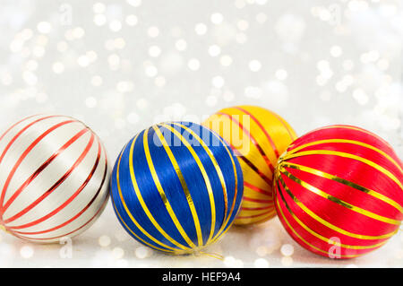 Trois boules de Noël colorées avec des lignes d'or sur fond blanc Banque D'Images