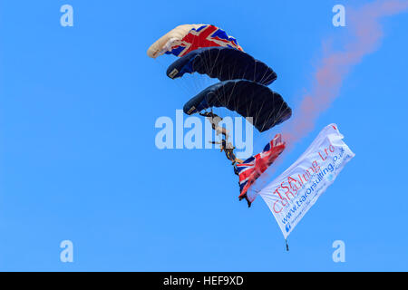 Trois des membres de l'ParachuteTeam Freefall Tigres empilés à l'approche de la terre en face de la foule au Salon aéronautique Southport Banque D'Images