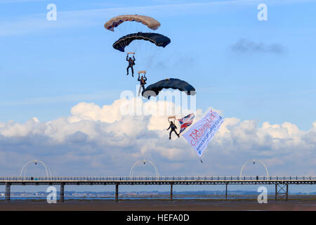 Trois des membres de l'ParachuteTeam Freefall Tigres empilés à l'approche de la terre en face de la foule au Salon aéronautique Southport Banque D'Images