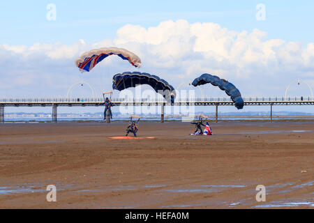 Trois des membres de l'ParachuteTeam Freefall Tigres empilés à l'approche de la terre en face de la foule au Salon aéronautique Southport Banque D'Images